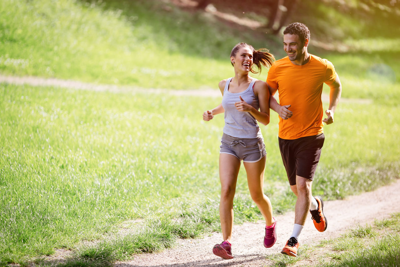Jak dbać o stawy – kobieta i mężczyzna biegający po parku.